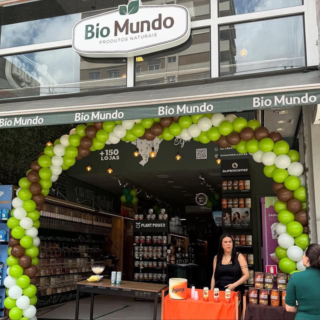 Fachada da loja Bio Mundo com arco de balões verdes na entrada.